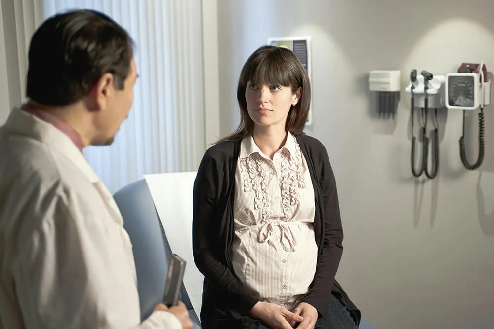 Pregnant woman speaking with her doctor