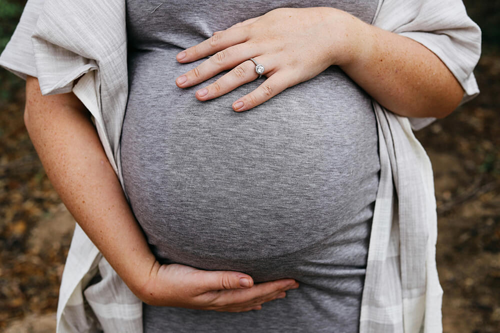 A pregnant woman holding her belly. 